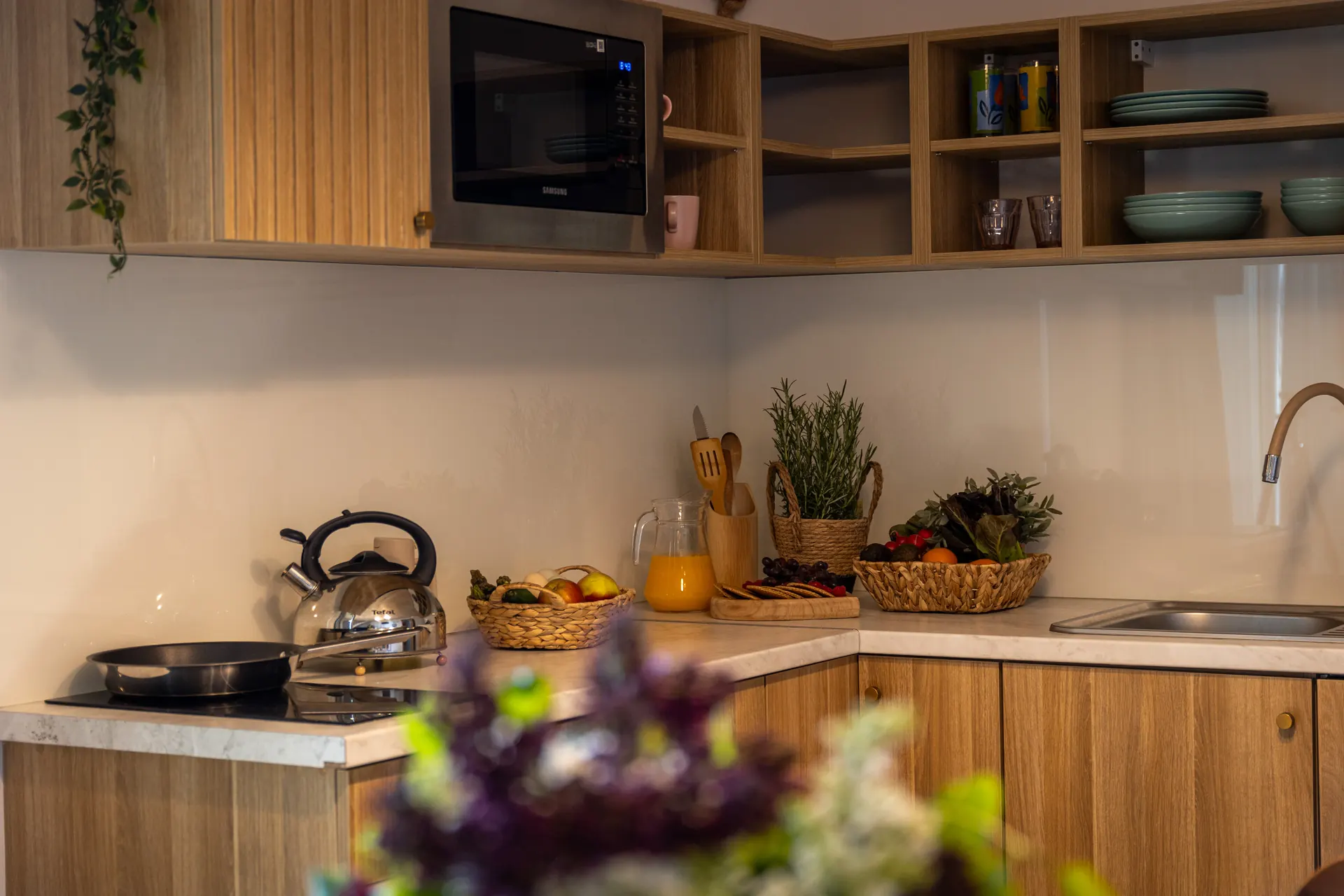 Aneks kuchenny z czajnikiem, mikrofalówką Samsung, koszami z owocami i warzywami — Apartament 1 Poezja Ciszy Dębki